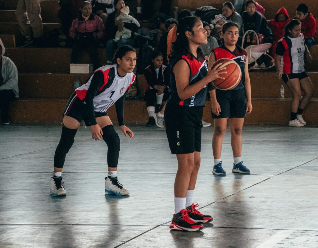 A group of young people playing a game of basketball